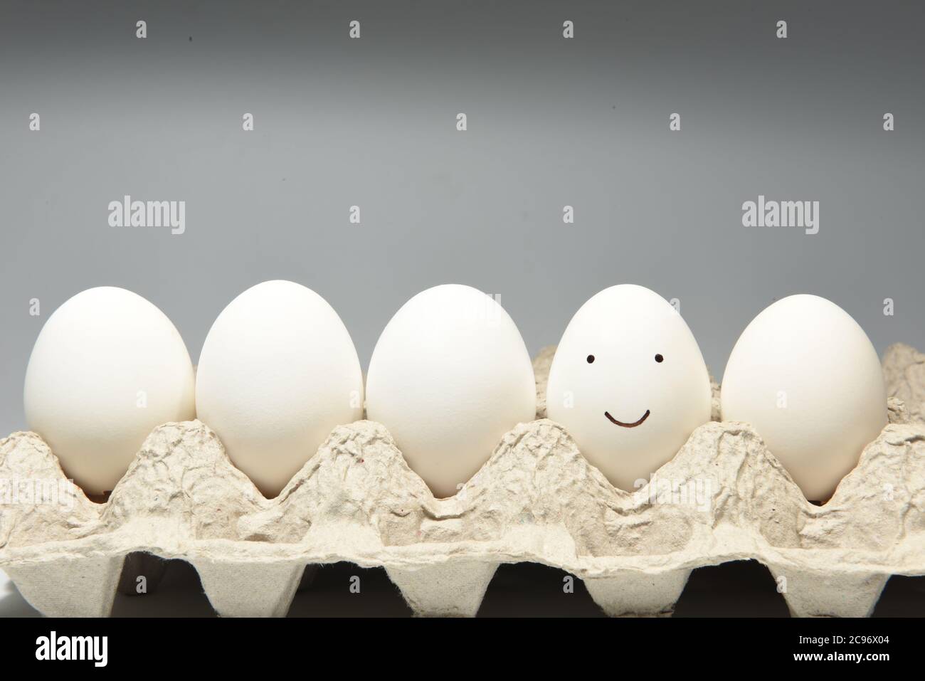 Dolce sorridente faccia emoji su un guscio di uovo Foto Stock