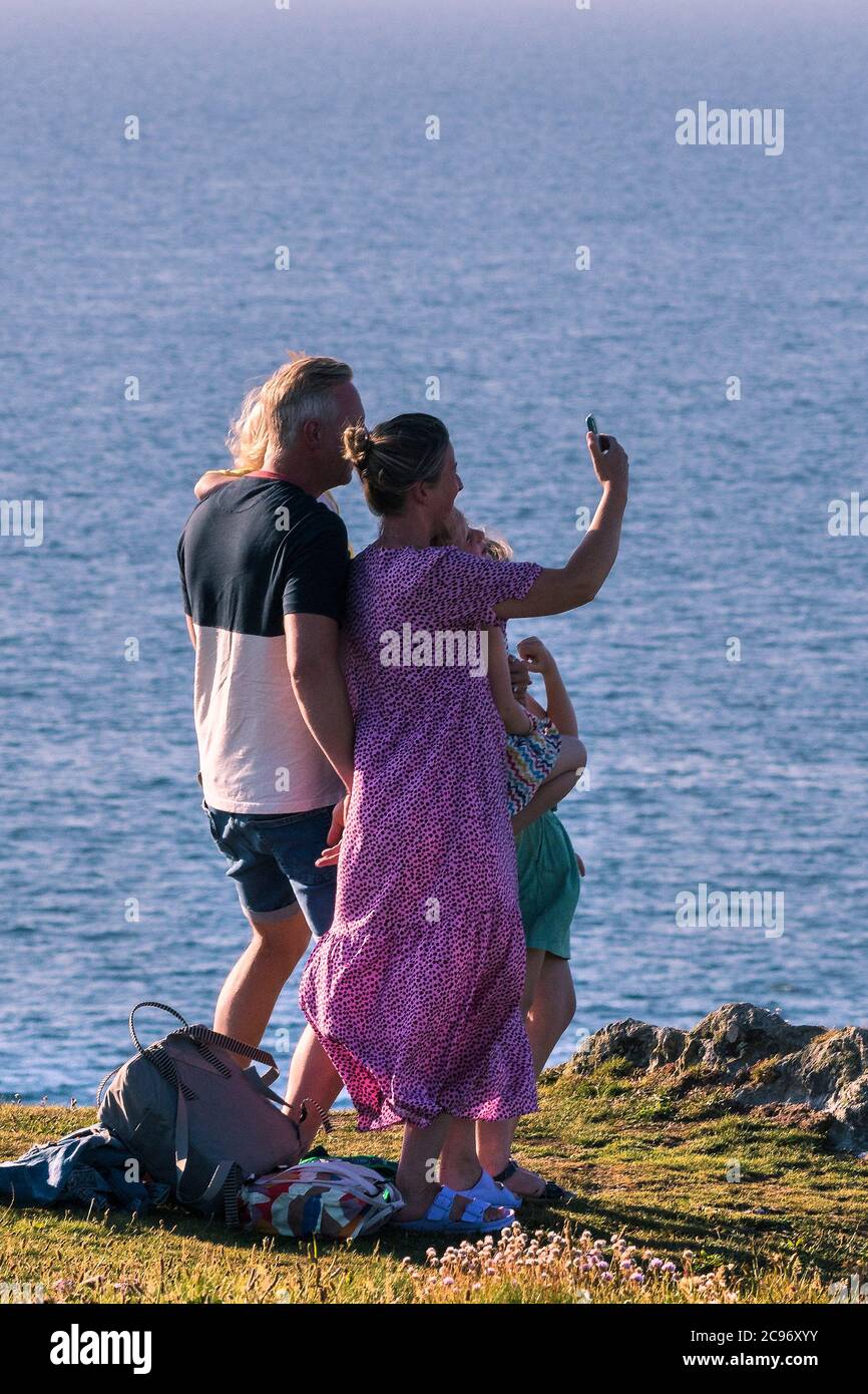 Una famiglia in vacanza staycation divertirsi scattando una foto selfie in piedi su Pentire Point East a Newquay in Cornovaglia. Foto Stock