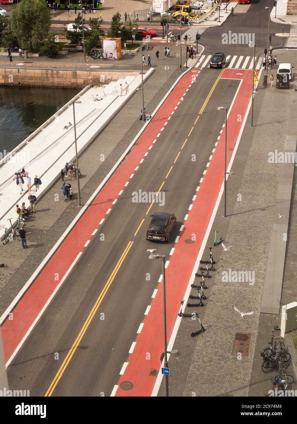 La pista ciclabile rossa in asfalto aggiunge colore e sottolinea il preferito Modalità di trasporto in Operagata nel quartiere di Bjorvika Centro di Oslo Norvegia Foto Stock