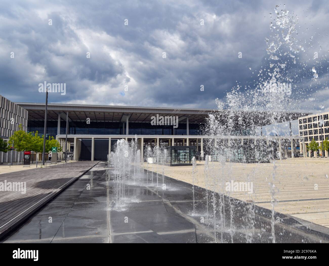 29 luglio 2020, Brandeburgo, Schönefeld: Una fontana si spruzzi di fronte al terminal dell'aeroporto di Berlino-Brandeburgo Willy Brandt (BER). Secondo l'operatore, l'apertura del Capital Airport BER è prevista per ottobre 2020. Dopo anni di ritardi, l'aeroporto inizierà a operare. La società di gestione è di proprietà degli stati di Berlino e Brandeburgo e del governo federale. Attualmente, circa 550 dipendenti e 400 volontari stanno provando la seconda fase del trasferimento operazionale e aeroportuale (ORAT). Si tratta di procedure standard per i passeggeri, dal check-in al check-in Foto Stock