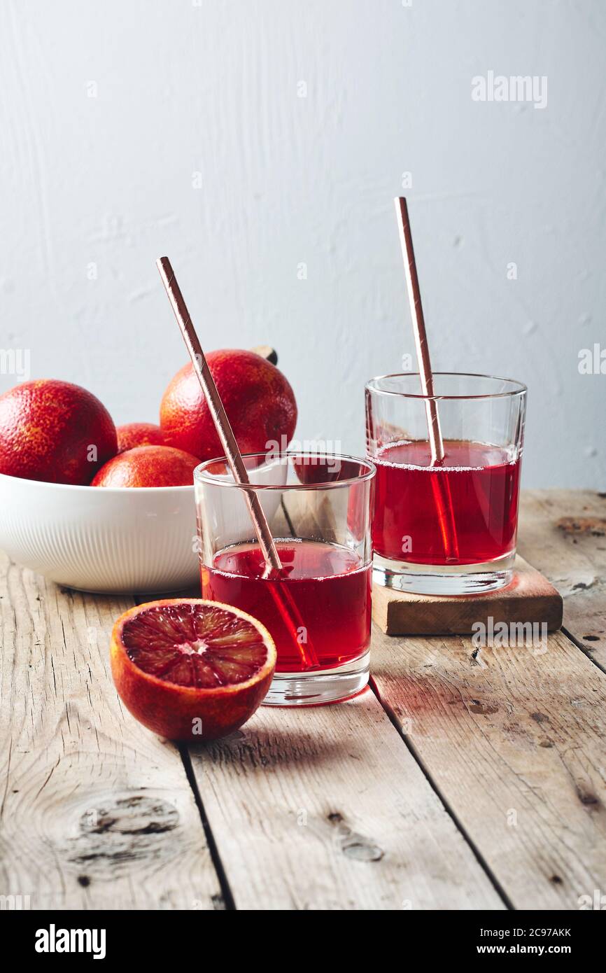 Cocktail rosso arancio sangue, agrumi su sfondo di legno. Foto Stock