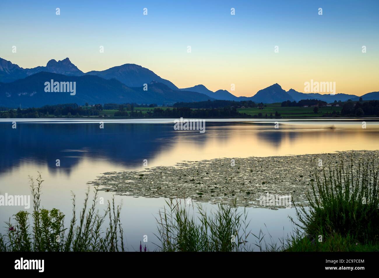 Vista dell'Hopfensee con le montagne di Tannheim sullo sfondo, Allgäu, Swabia, Baviera, Germania Foto Stock