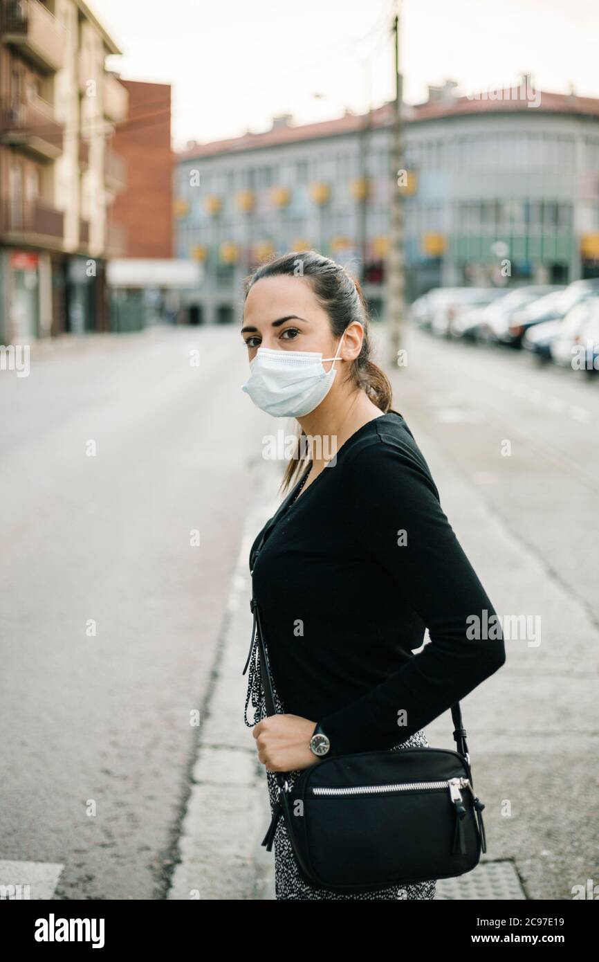 Donna spagnola che indossa una maschera protettiva per la strada. Stile di vita del coronavirus Foto Stock