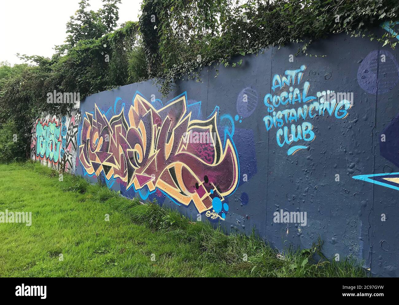 Graffiti topici spruzzati su un muro di graffiti a Swansea, Regno Unito, dicendo "Anti Social Distancing Club". Foto Stock Graffiti topici spruzzati su un muro di graffiti a Swansea, Regno Unito, dicendo "Anti Social Distancing Club". Foto Stock