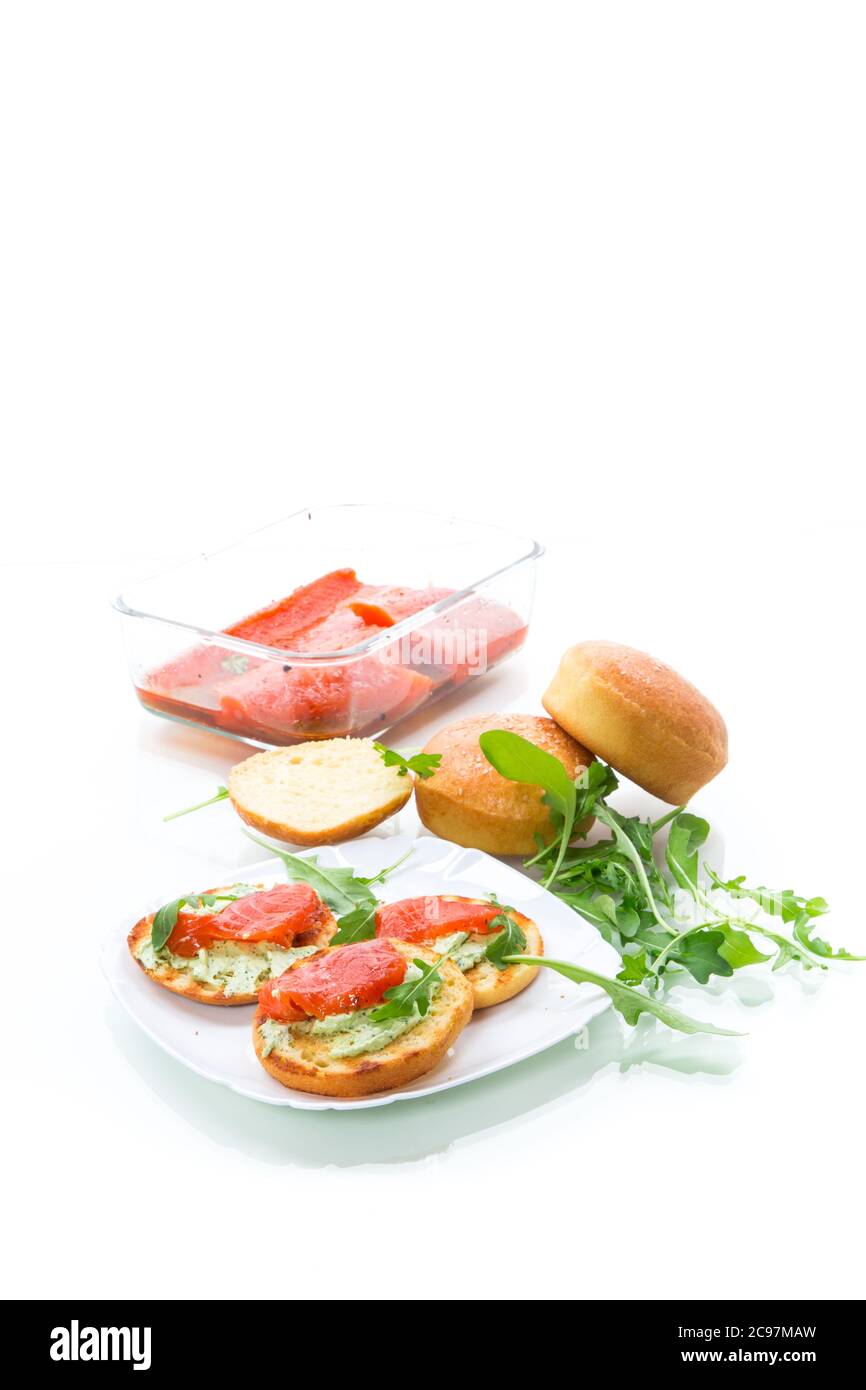 sandwich con panino fritto, formaggio spalmato e pesce rosso in un piatto isolato su sfondo bianco Foto Stock