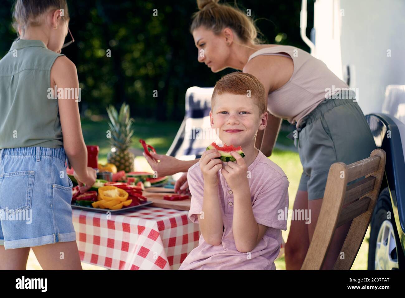 Legga il capo ragazzo con la famiglia al campeggio Foto Stock
