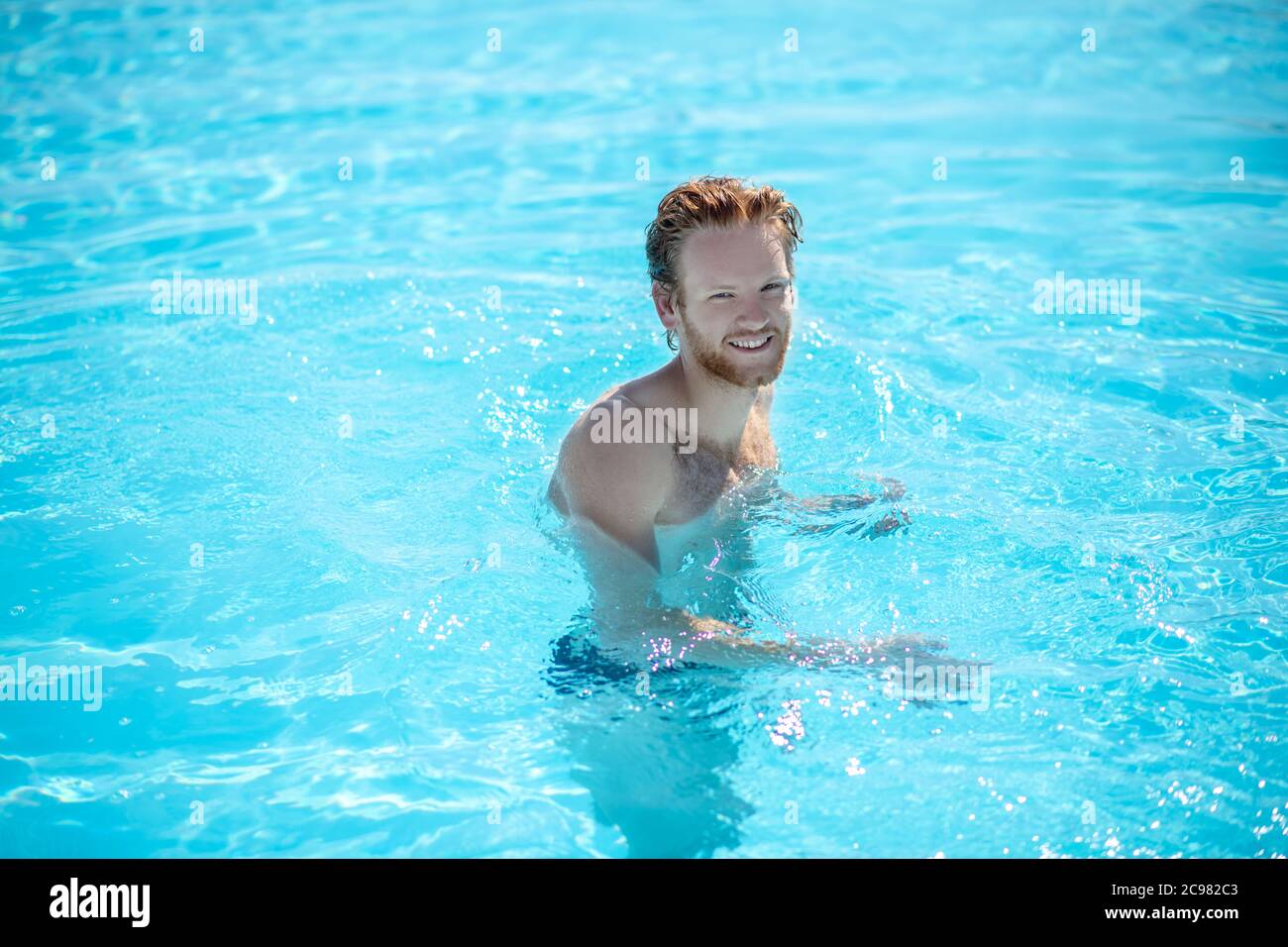 Uomo sorridente riuscito nell'acqua della spalla-lunghezza Foto Stock