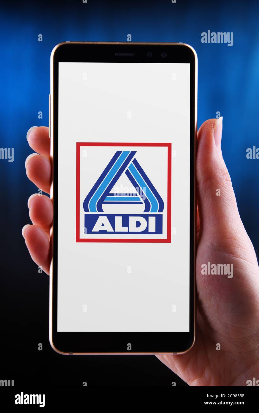 POZNAN, POL - 21 MAGGIO 2020: Smartphone a mani in mano con il logo di Aldi, il marchio della catena globale di supermercati a gestione familiare con sede in Germania Foto Stock