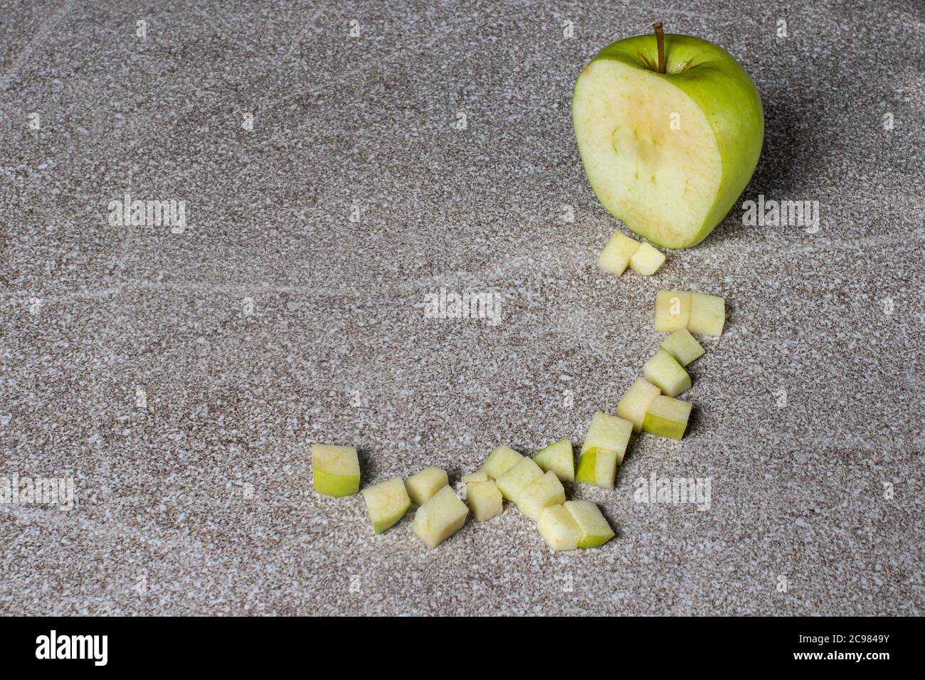 Verde mela succosa Golden su sfondo grigio. Mele a cubetti. Foto Stock