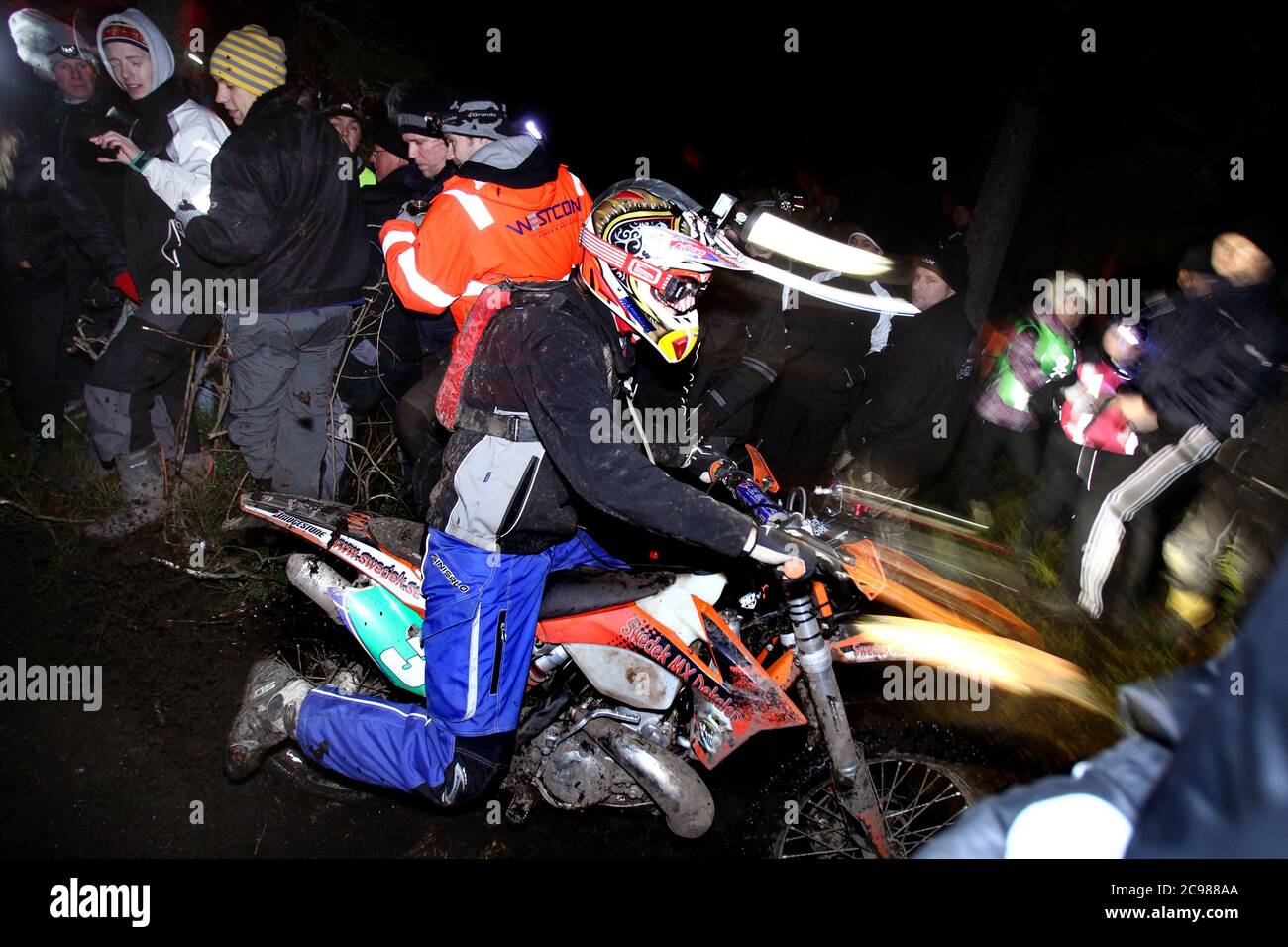 Åsbro, Svezia 2011 una delle competizioni enduro più impegnative del mondo, Novemberkåsan a Åsbro, appena a sud di Örebro. Nella foto: Linus Fasth, LMS, ha guidato attraverso il mare di ​​people nella foresta sotto Novemberkåsan a Åsbro. Novemberkåsan è uno degli eventi motociclistici più antichi e più grandi della Svezia. Si tiene dal 1915. Foto Gippe Gustafsson Foto Stock