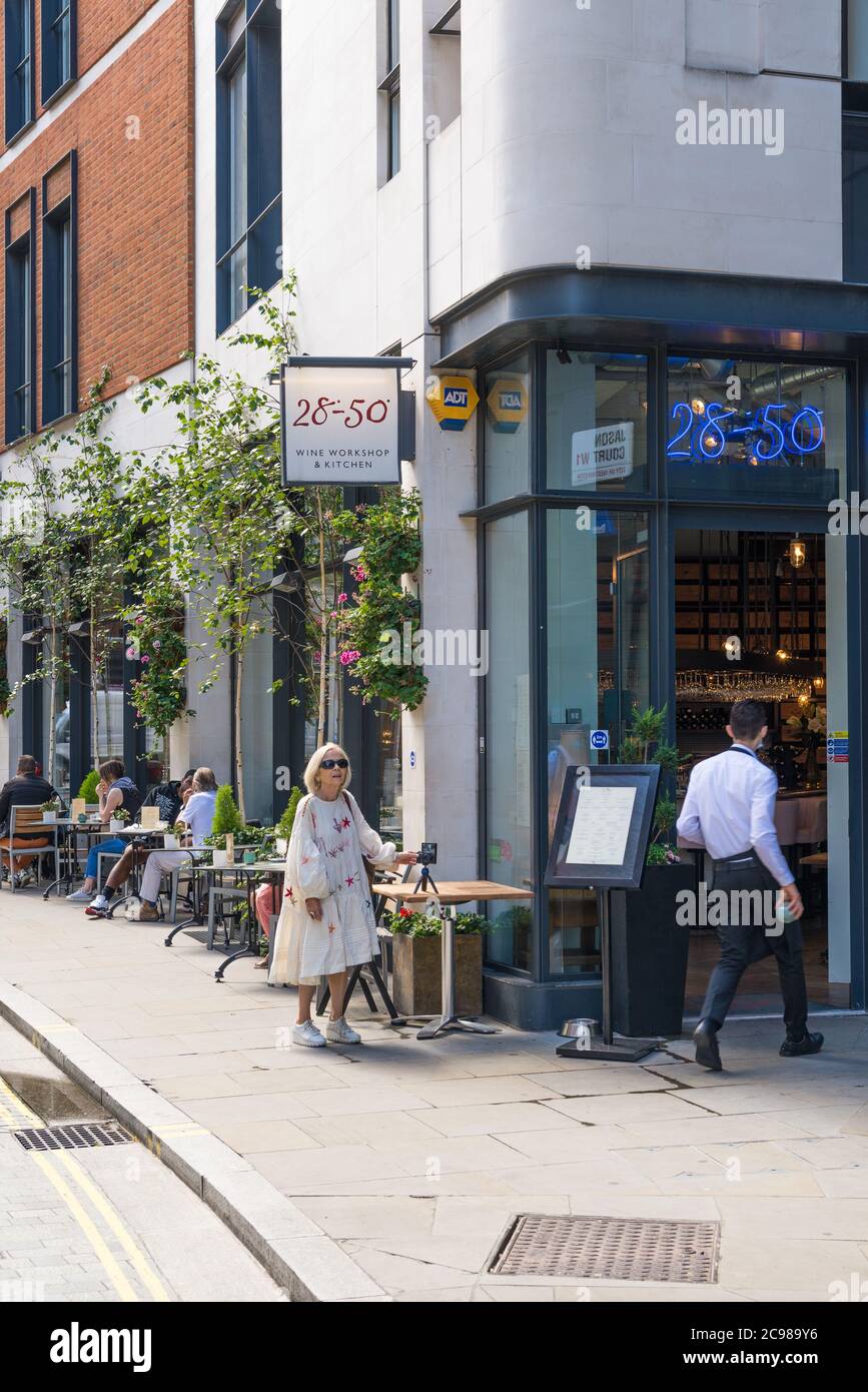 Le persone seduti ai tavoli da pranzo al fresco al 28-50 Wine Workshop e Kitchen Wine bar bistro, Marylebone Lane, Londra, Inghilterra, Regno Unito Foto Stock