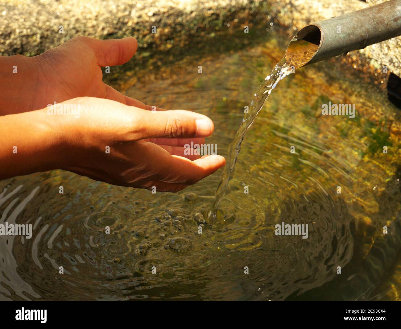 Nelle calde giornate estive, i turisti vengono a rinfrescarsi e bere acqua dalle fontane del villaggio Foto Stock
