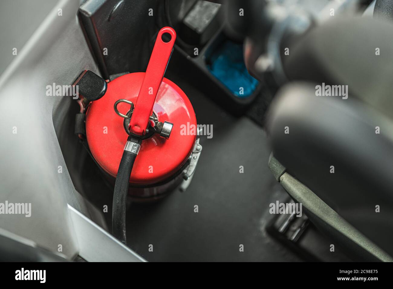 Estintore rosso di medie dimensioni all'interno del veicolo autobus. Tema sicurezza antincendio per l'automobile. Foto Stock