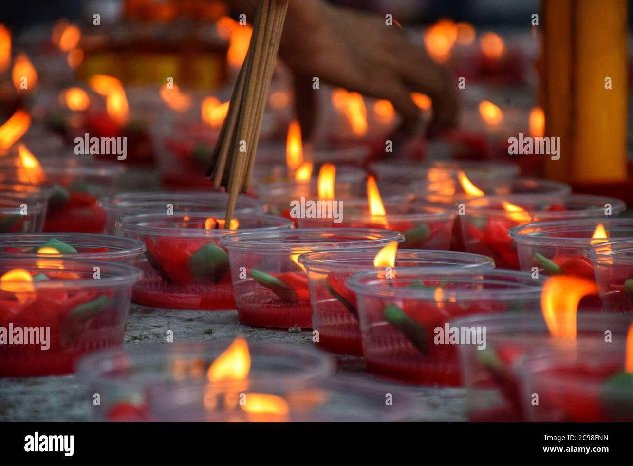 Accendi i bastoncini d'incenso con la candela rossa - Festival di primavera Foto Stock