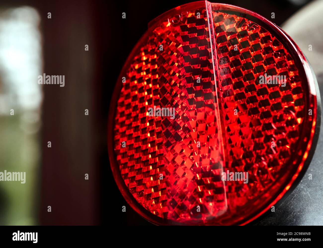 Catarifrangente rosso rotondo su una bicicletta per aumentare la sicurezza stradale Foto Stock