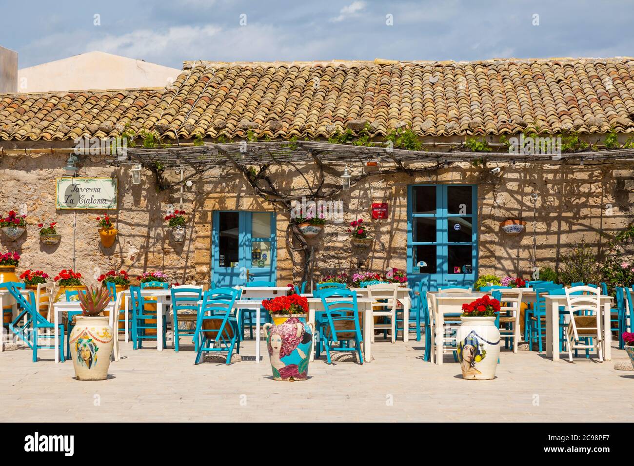 Tavoli e sedie colouful in Piazza Regina Margherita in frazione Marzamemi, Sicilia Foto Stock