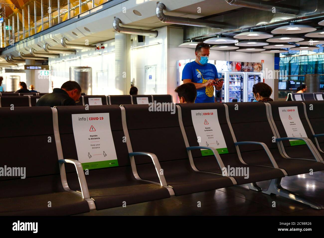 28 luglio 2020, Aeroporto Barajas, Madrid, Spagna: Cartelli sui posti per aiutare i passeggeri a rispettare le distanze sociali nella vicina area lounge delle partenze dell'edificio del Terminal 4S dell'aeroporto di Barajas. Un numero ridotto di voli è ora operativo tra i paesi europei dopo il blocco per controllare il coronavirus della covid-19, e i governi hanno messo in atto un sistema di ponti aerei per facilitare i viaggi e il turismo. La Spagna ha visto una serie di nuovi focolai negli ultimi giorni, inducendo il governo britannico ad annunciare che le persone che tornano nel Regno Unito dalla Spagna dovrebbero essere in quarantena per 14 giorni all'arrivo. Foto Stock