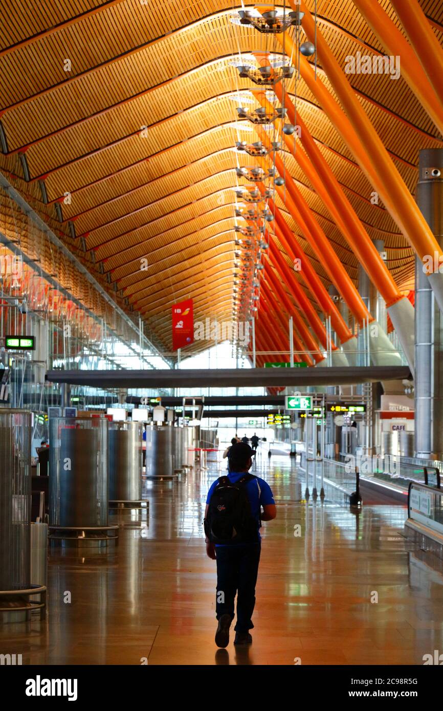 28 luglio 2020, Aeroporto Barajas, Madrid, Spagna: Un passeggero cammina attraverso la vicina area lounge delle porte di partenza empy dell'edificio del Terminal 4S dell'Aeroporto Barajas. Un numero ridotto di voli è ora operativo tra i paesi europei dopo il blocco per controllare il coronavirus della covid-19, e i governi hanno messo in atto un sistema di ponti aerei per facilitare i viaggi e il turismo. La Spagna ha visto una serie di nuovi focolai negli ultimi giorni, inducendo il governo britannico ad annunciare che le persone che tornano nel Regno Unito dalla Spagna dovrebbero essere in quarantena per 14 giorni all'arrivo. Foto Stock