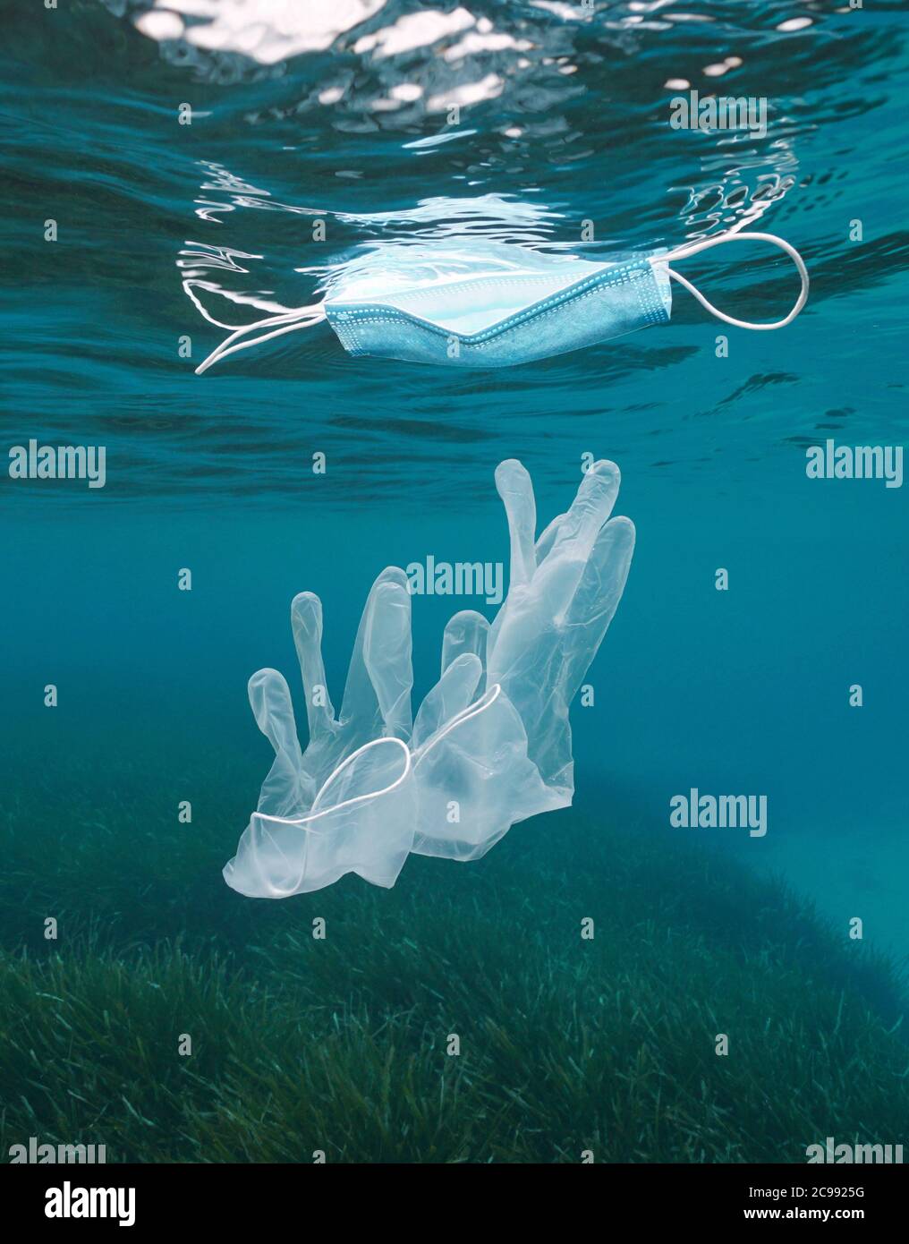 Guanti subacquei e maschera facciale galleggianti sulla superficie dell'acqua, inquinamento da rifiuti plastici in mare, coronavirus COVID-19 pandemia, Mar Mediterraneo Foto Stock