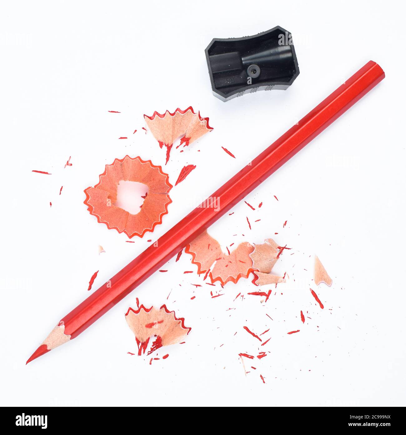 Materiali di studio contenenti una matita rossa e un singolo affilatore in plastica di colore nero Foto Stock