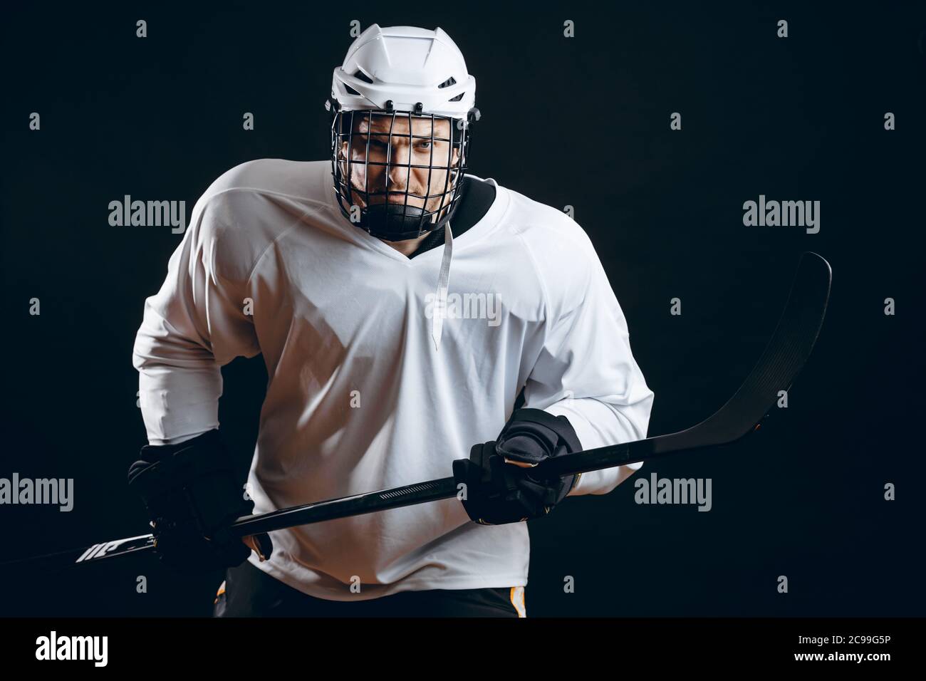 Immagine del giocatore di hockey su ghiaccio in abbigliamento sportivo  bianco con bastone da hockey preparati alla difesa Foto stock - Alamy