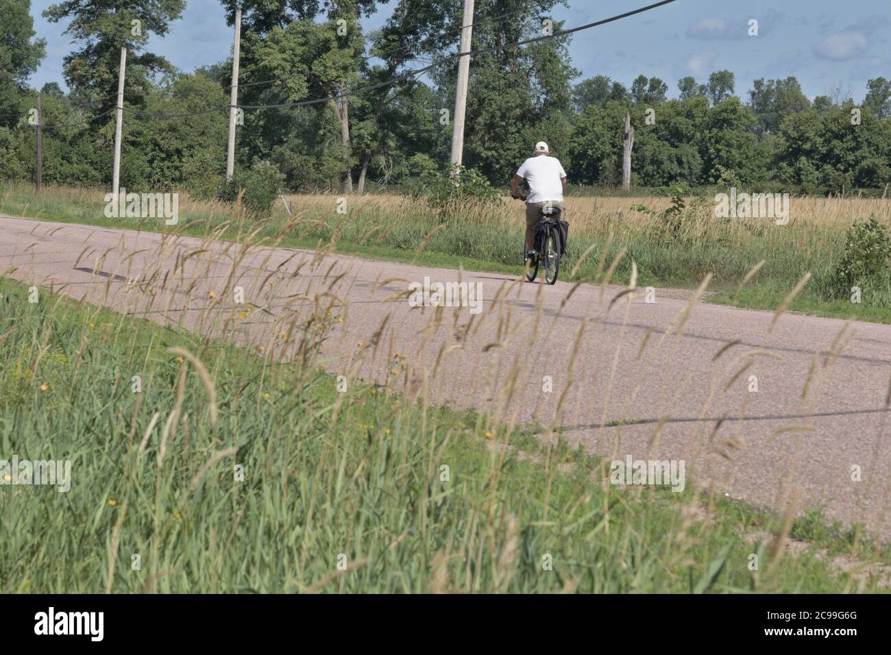 uomo che va in bicicletta lungo la vecchia strada di campagna Foto Stock