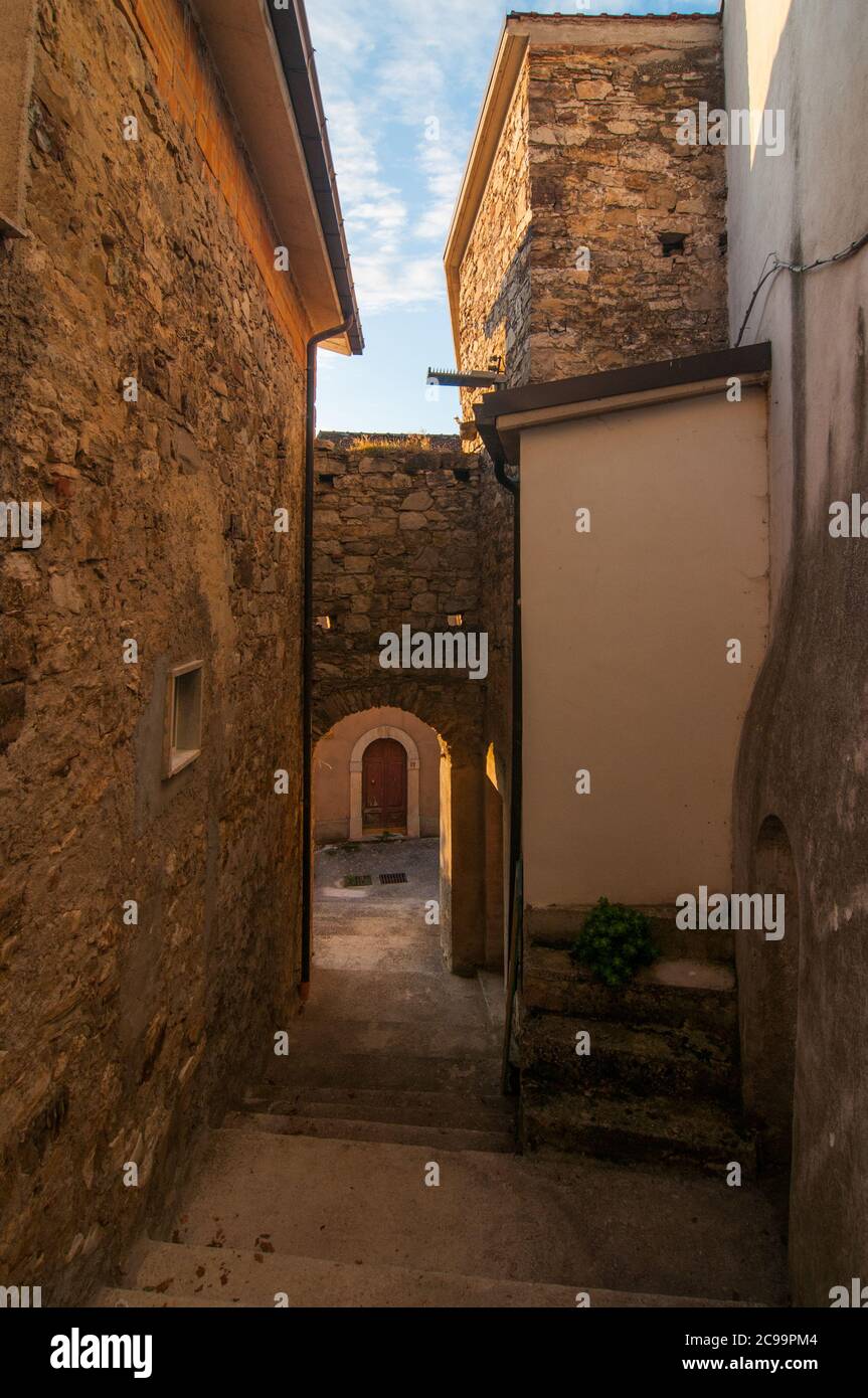 Una tipica strada storica nel villaggio italiano di Torella Di Sannio in Molise con edifici in mattoni e un arco Foto Stock