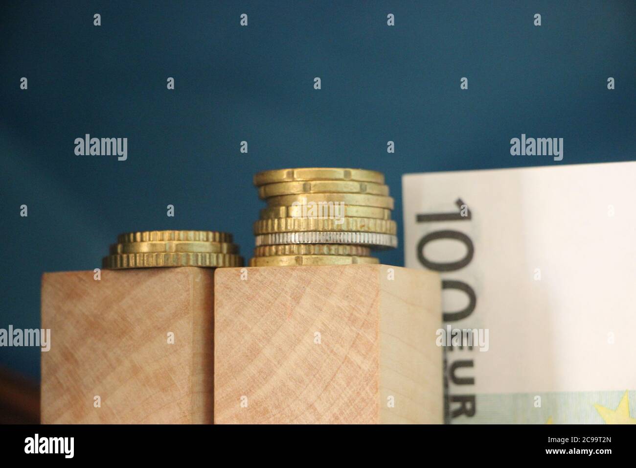 2 pile di monete in euro e 100 euro di bolletta. Il concetto di crescita del profitto aziendale Foto Stock