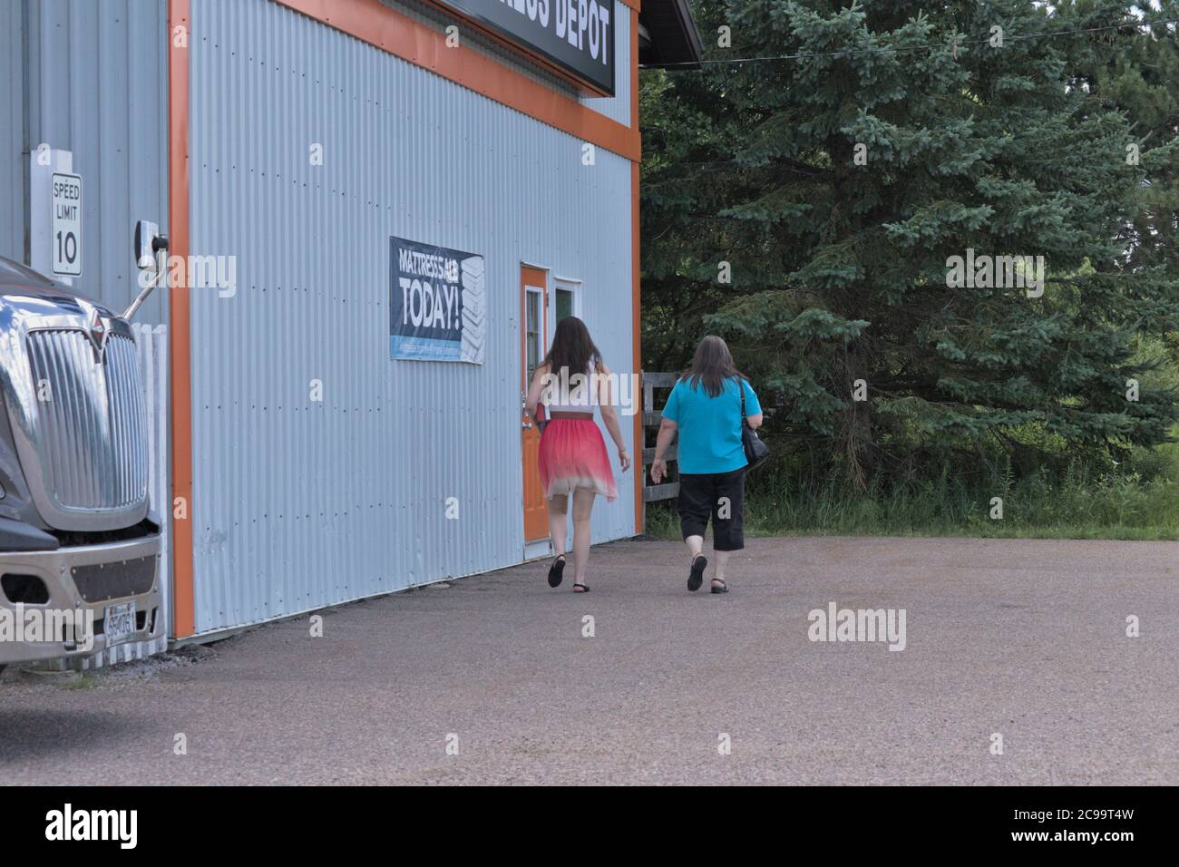 Due donne che entrano in un'azienda Foto Stock