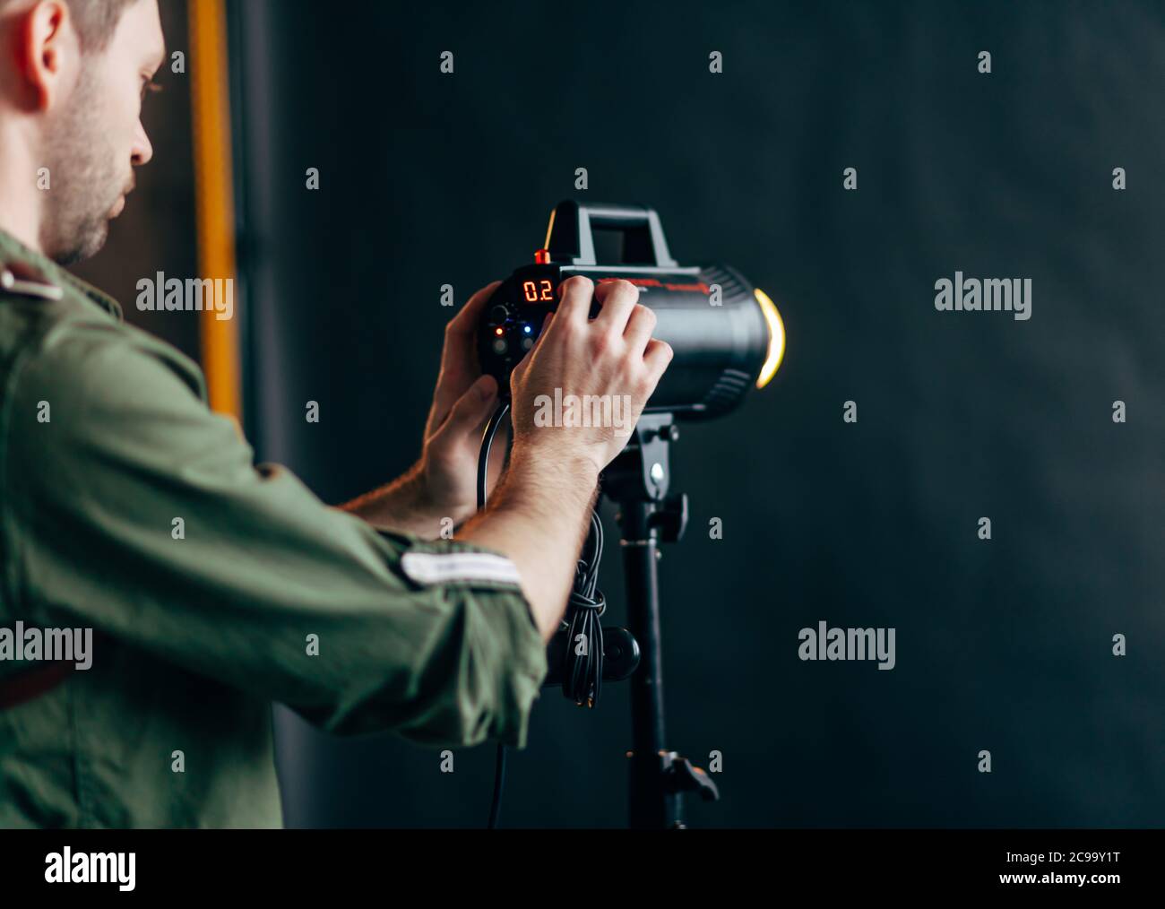 attrezzature da studio per l'illuminazione utili per la fotografia.primo piano foto ritagliata, ragazzo che accende la luce Foto Stock