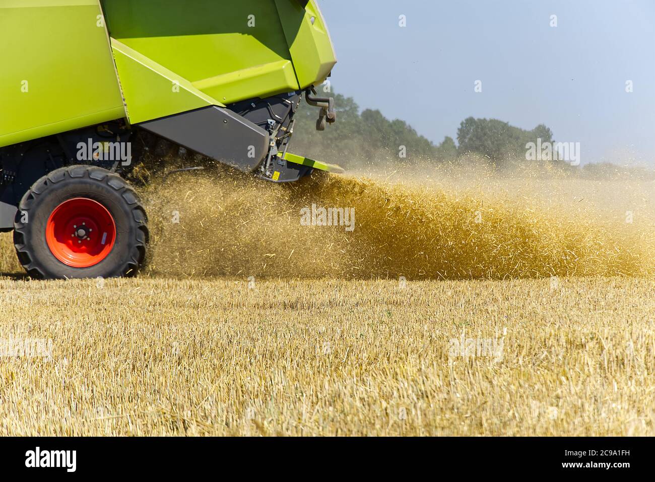mietitrice in funzione durante la giornata calda estiva, arrossata - fuori fuoco. Foto Stock