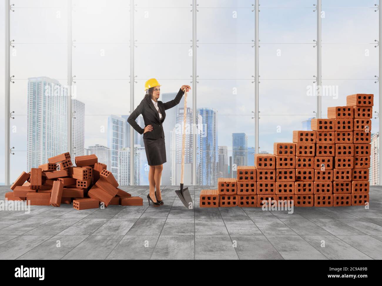 Donna d'affari con casco costruisce una barra crescente di statistiche con mattoni Foto Stock