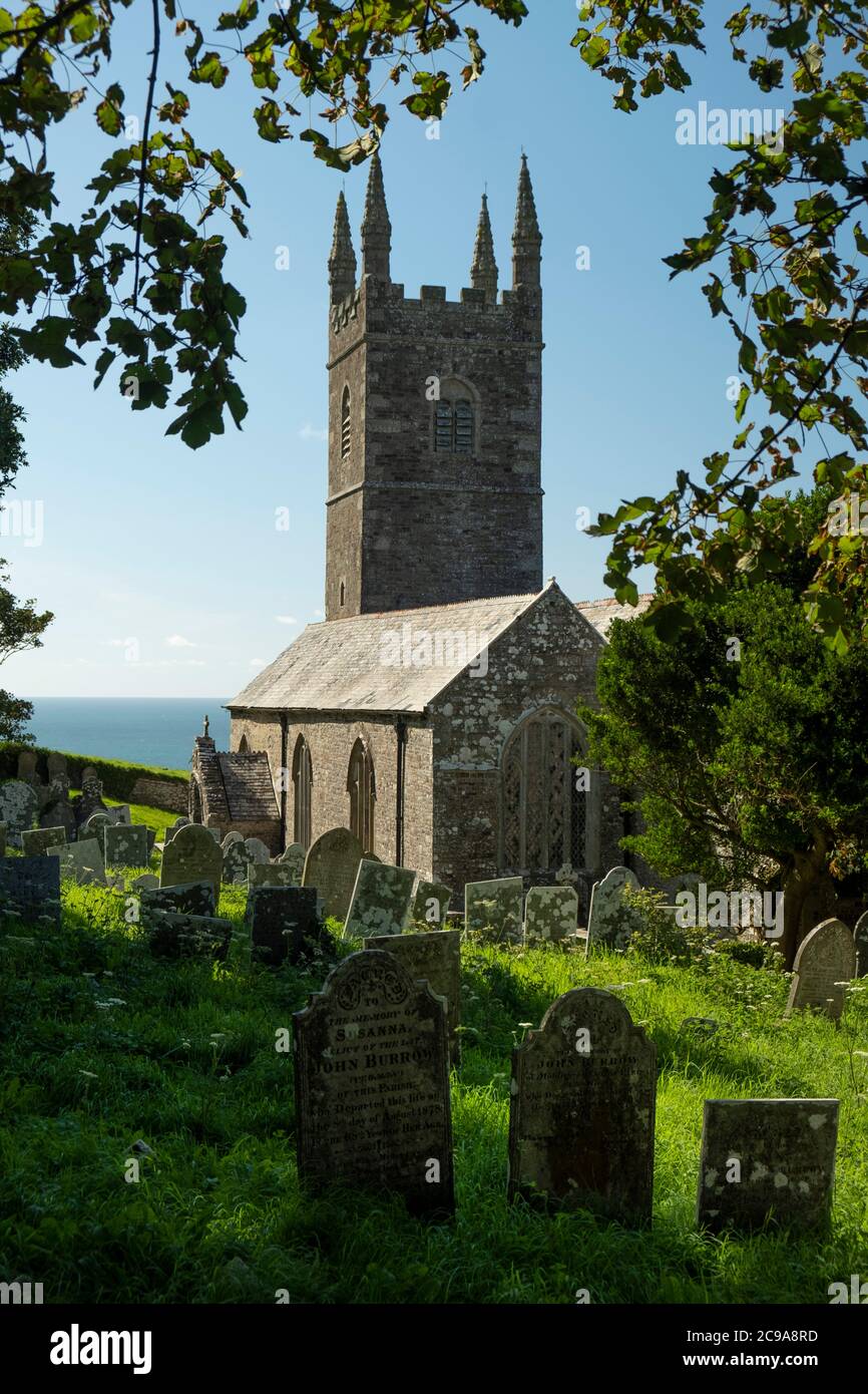 La Chiesa Parrocchiale di San Morwenna e San Giovanni Battista, Morwenstow, Cornovaglia, Regno Unito, con vecchie lapidi accatastate nel cortile. Foto Stock