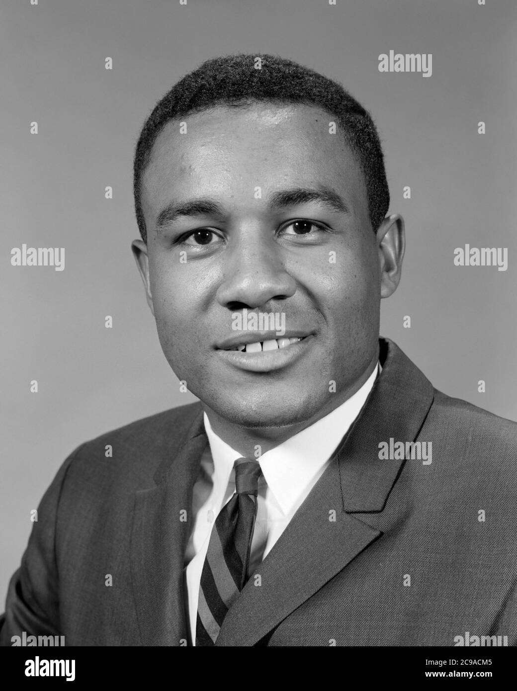 RITRATTO DEGLI ANNI '60 UOMO AFROAMERICANO CHE INDOSSA ABITO E CRAVATTA SORRIDENTE GUARDANDO LA FOTOCAMERA - N2123 HAR001 HARS ALLEGRO AFROAMERICANI AFROAMERICANI E LEADERSHIP NERO ETNIA ORGOGLIO SORRIDE GIOIOSO STILE SINCERO MESSO A FUOCO INTENSO MID-ADULT MID-ADULT UOMO GIOVANE ADULTO UOMO NERO E BIANCO EARNEST HAR001 INTENTO VECCHIO STILE AFROAMERICANI Foto Stock