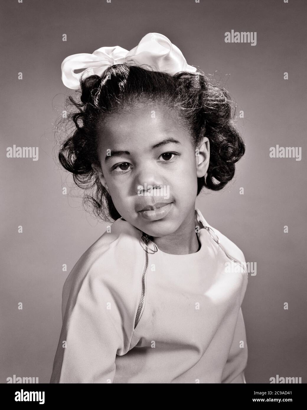 1960S RITRATTO DI AFROAMERICANA RAGAZZA CON ARCO NEI CAPELLI CHE INDOSSA TOP CON ZIP GUARDANDO FOTOCAMERA CON ESPRESSIONE SERIA - N2411 HAR001 HARS COMUNICAZIONE PREOCCUPAZIONE STILE DI VITA FEMMINE MOODY HOME VITA MEZZA LUNGHEZZA CURA FIDUCIA ESPRESSIONI TURBATO B&W INTERESSATO TRISTEZZA OCCHIO CONTATTO SOGNI AFROAMERICANI CORAGGIO AFROAMERICANO ETNIA NERA ETNIA ORGOGLIO OPPORTUNITÀ DI UMORE GLUM CONCETTUALE CRESCITA ELEGANTE GIOVANI MISERABILI INTERROGANDO NERO E BIANCO DIRETTO HAR001 VECCHIO STILE AFROAMERICANI Foto Stock