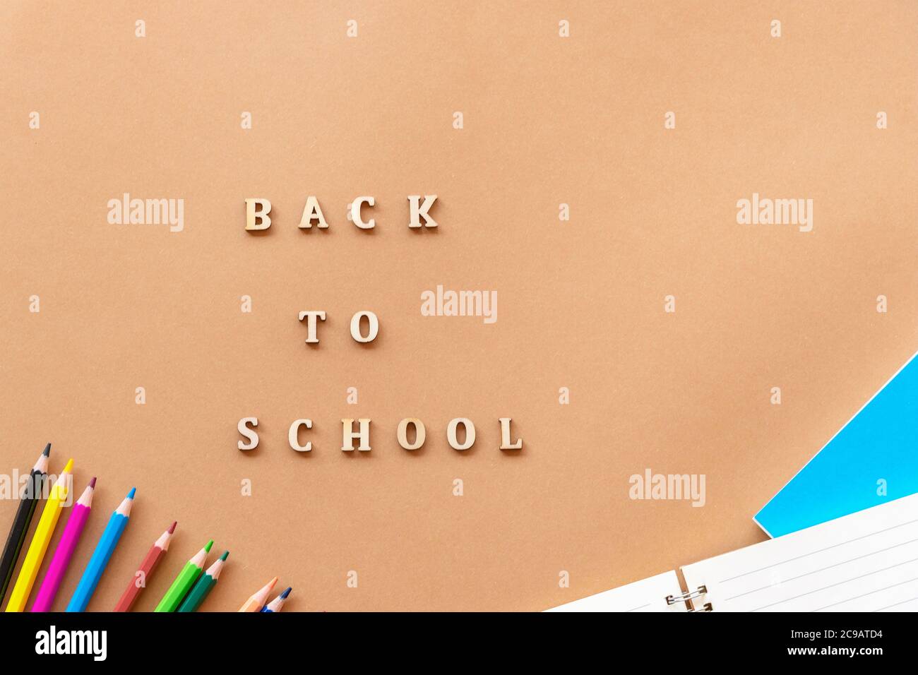 Forniture scolastiche su sfondo beige e parole ritorno a scuola, piatto. Foto Stock
