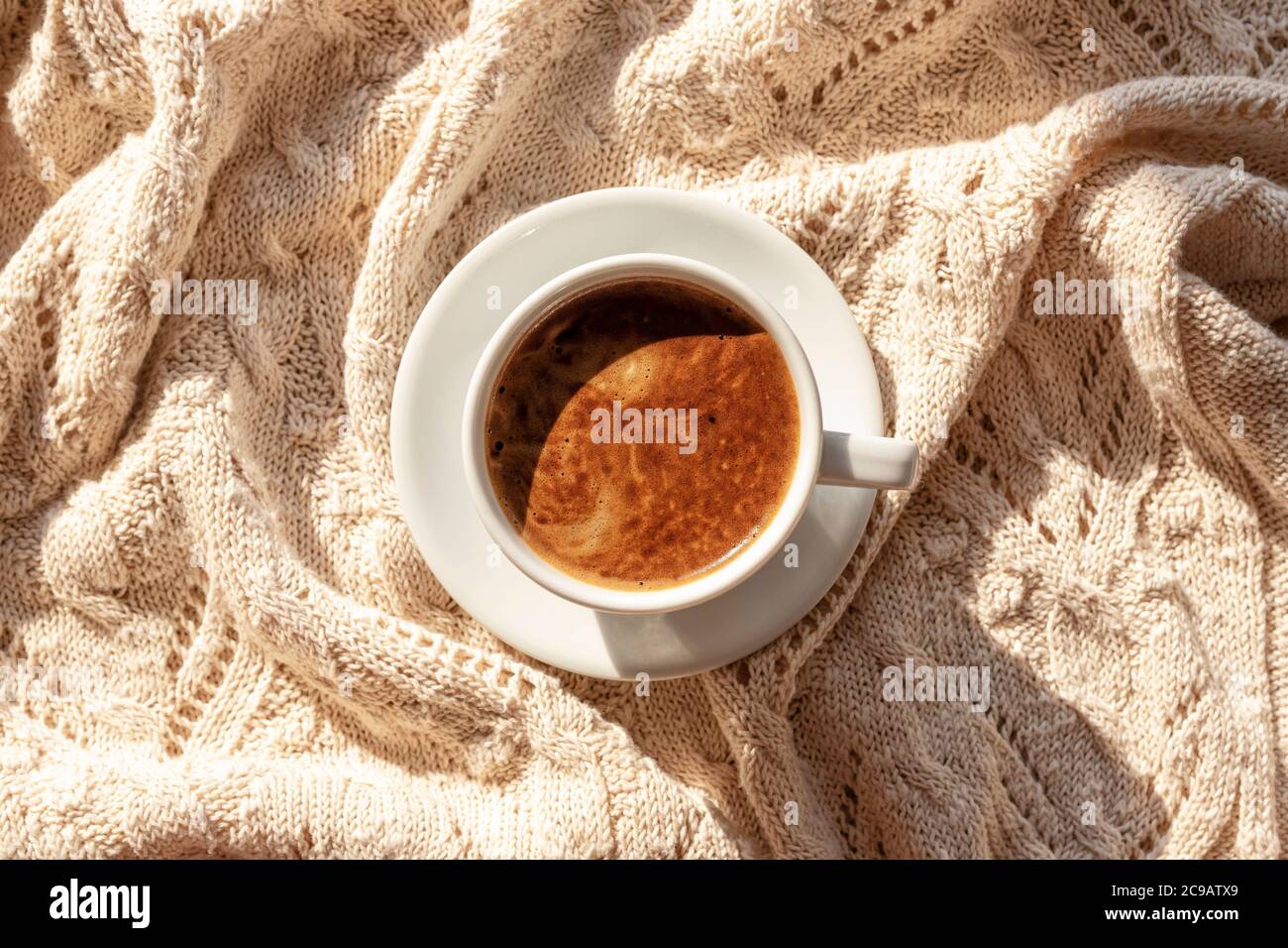 Tazza di caffè o cioccolata calda su comoda coperta a maglia, vista dall'alto, disposizione piatta Foto Stock