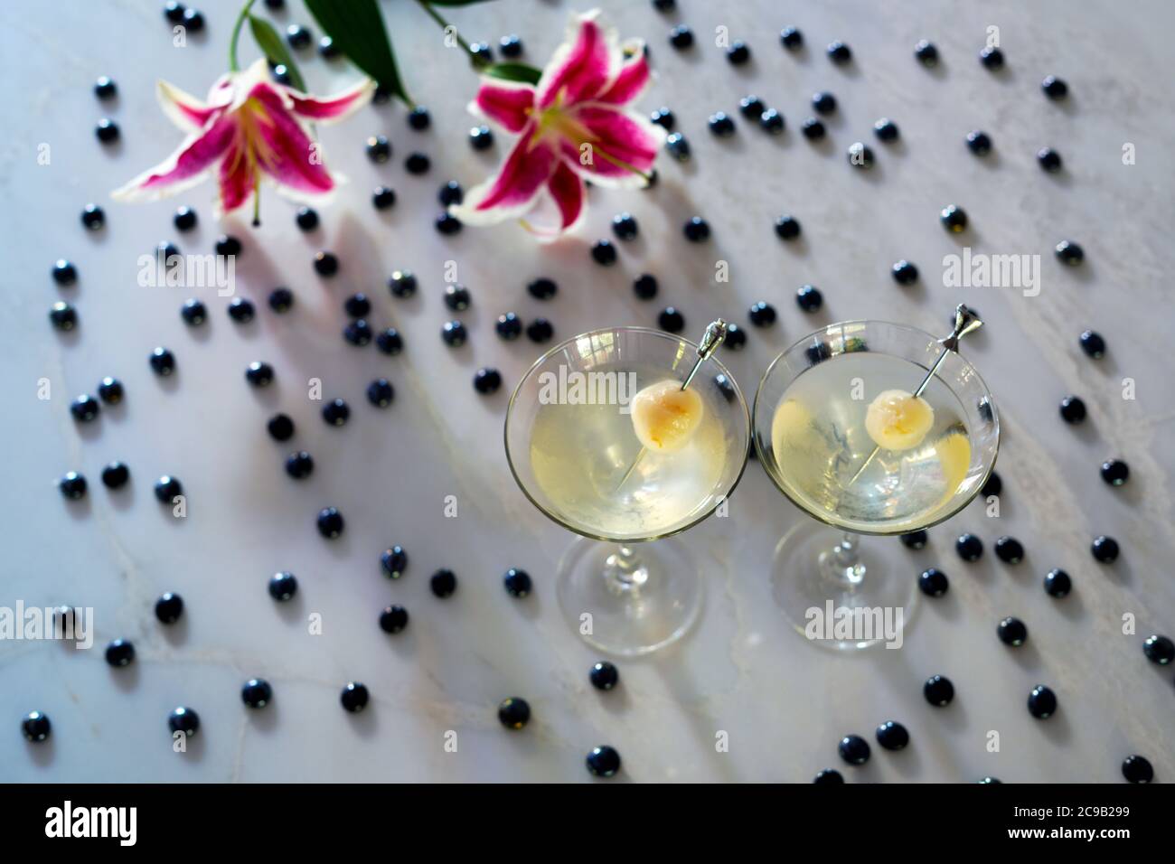 Lychee Martinis con alcuni gigli rosa Foto Stock