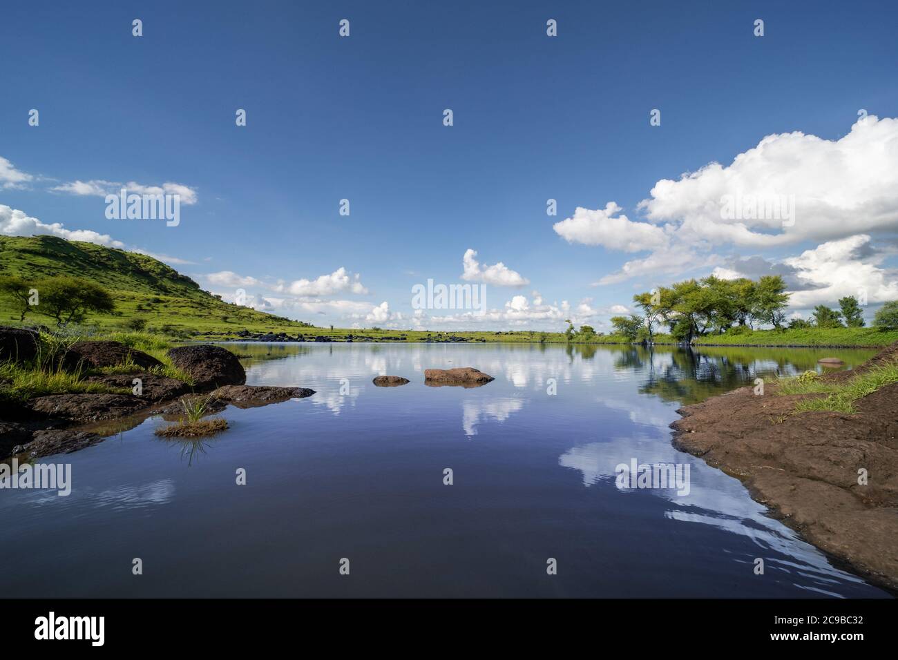 Vista lago lato collina con cielo blu Foto Stock