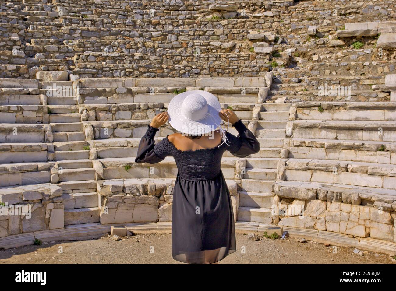 Bella giovane donna in abito nero nella città antica di Efeso Foto Stock