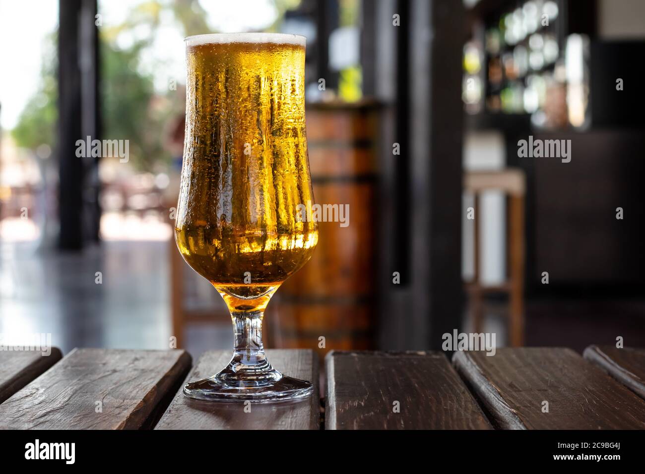 Bicchiere di birra su un tavolo di legno in un pub, bar. Bevanda alcolica. Concetto di festa e svago Foto Stock