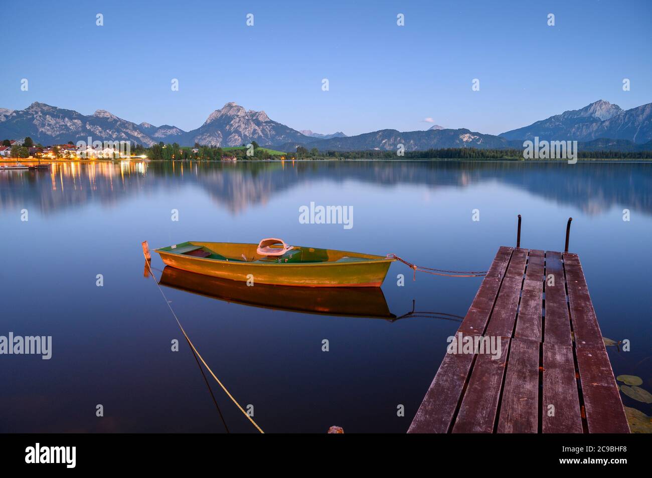 Hopfensee con barca a remi e molo in legno, sullo sfondo i Monti Tannheim, Allgäu, Baviera, Germania Foto Stock