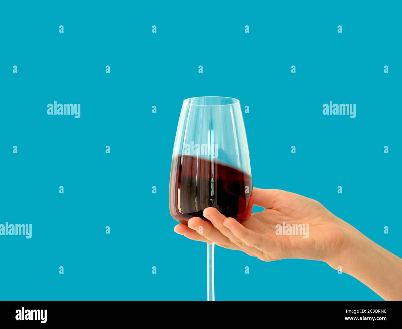 Mano con bicchieri di vino rosso Foto Stock