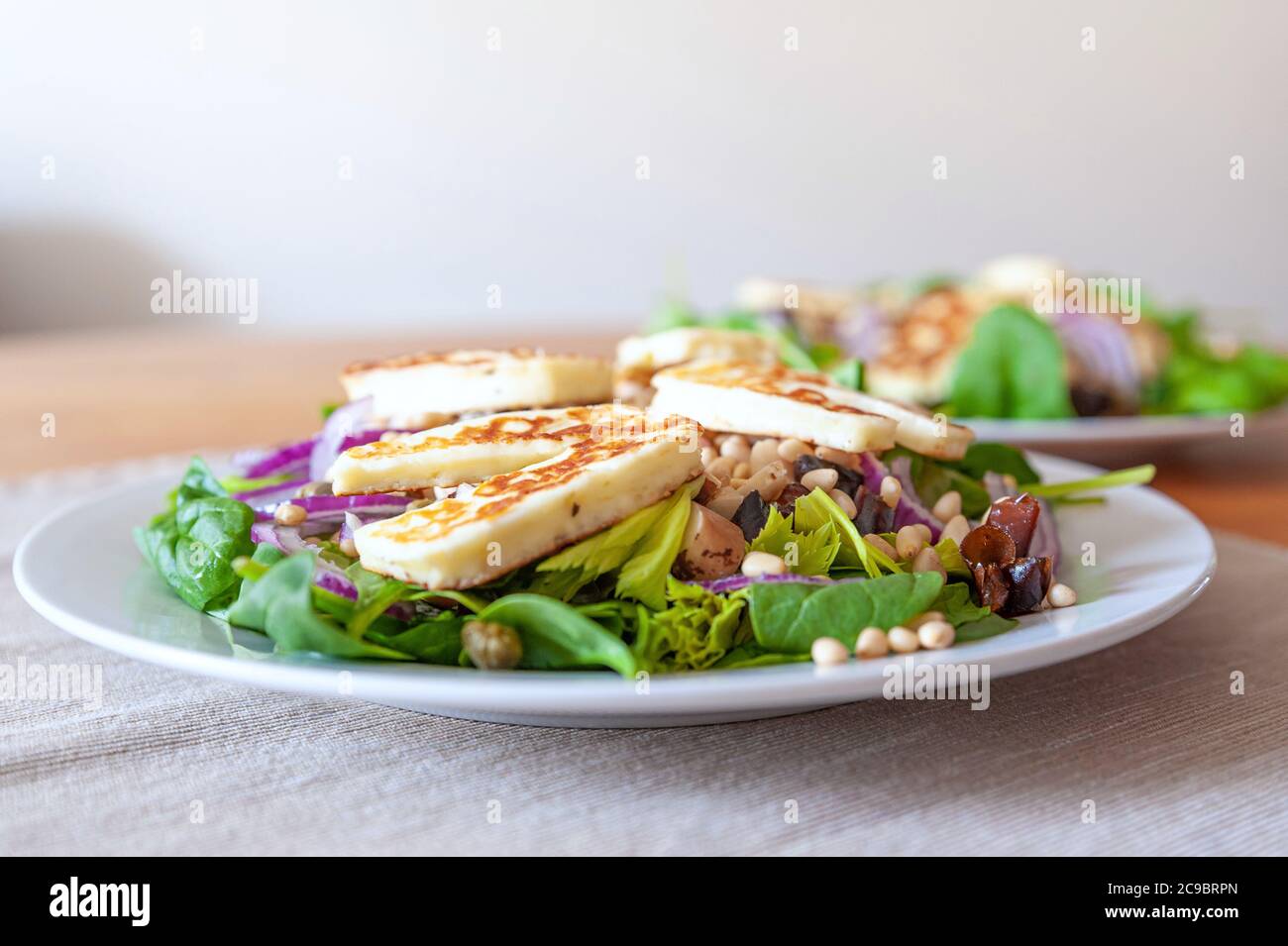Insalata vegetale fresca e sana con pezzi di formaggio di capra alloumi alla griglia in cima. Foto Stock