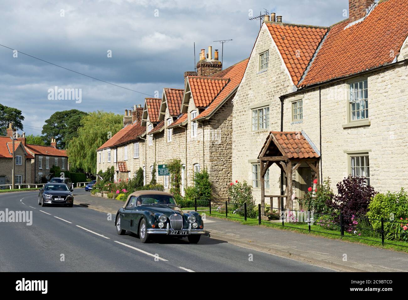 Jaguar XK150 nel villaggio di Hovingham, Ryedale, North Yorkshire, Inghilterra Regno Unito Foto Stock