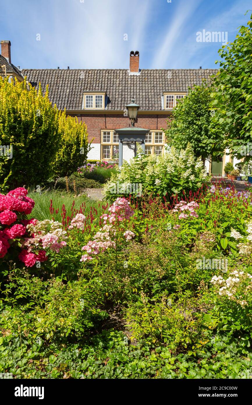 Cortile con giardino e piccole case nel centro della città di Leiden nei Paesi Bassi, in Europa Foto Stock