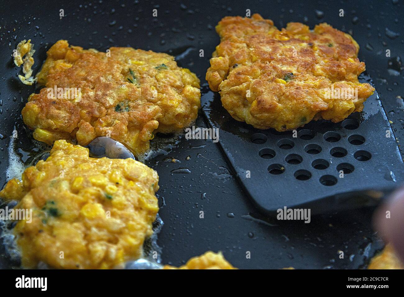 Un primo piano di frittelle di mais cucinate in una padella. Foto Stock