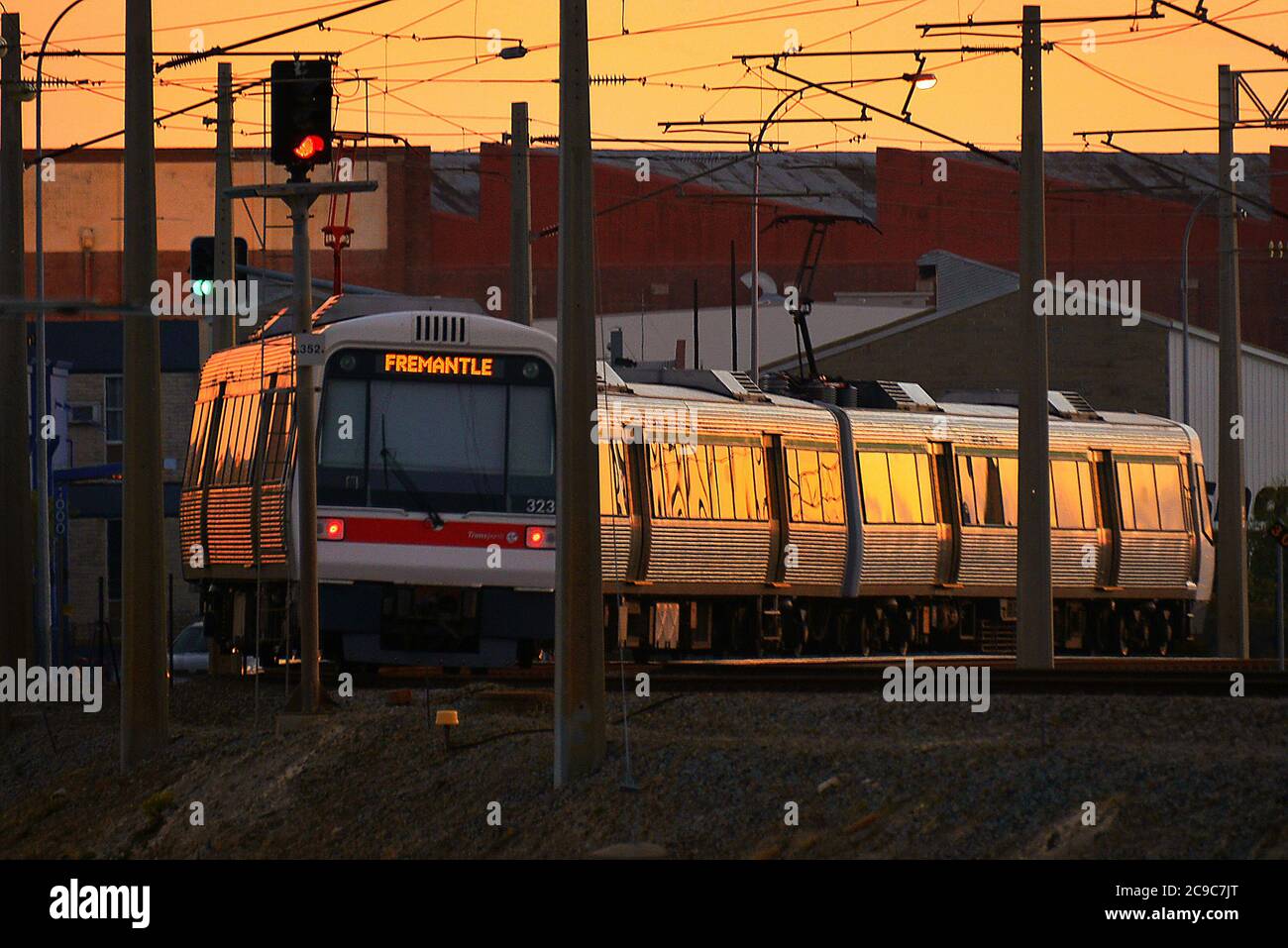 Il tramonto riflette il lavoro metallico di un treno elettrico, in direzione di Fremantle, Australia occidentale. Foto Stock