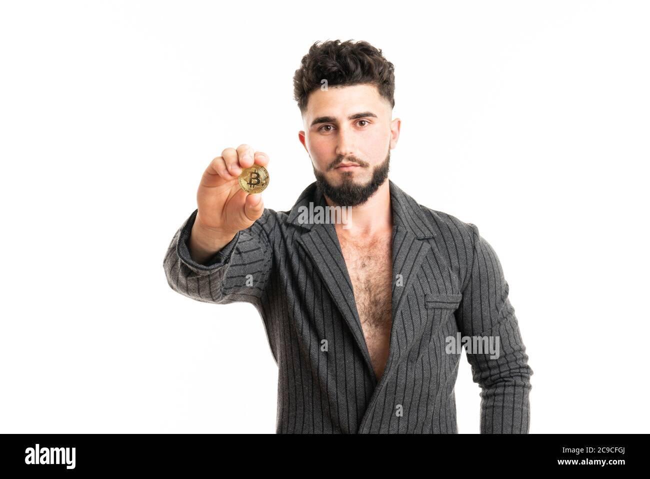 Un uomo d'affari in un vestito tiene in mano a. oro bitcoin isolato su sfondo bianco Foto Stock