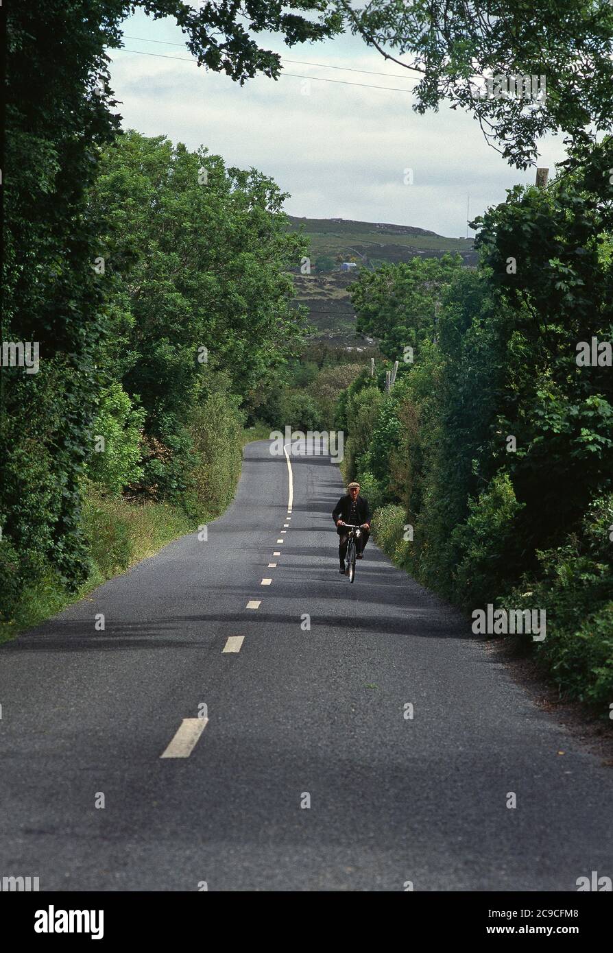 Uomo in bicicletta che si dirige a casa lungo la Wild Atlantic Way, Irlanda, Foto Stock